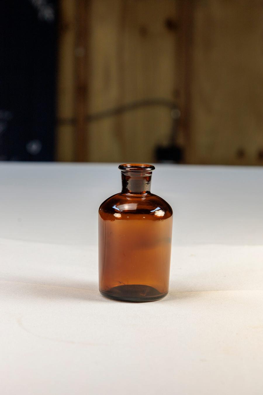 Amber apothecary bud bottles for single-stem florals.