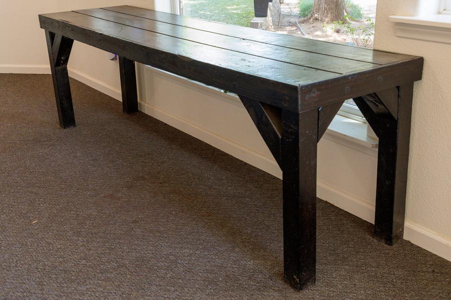 A black stained farmhouse wood bench.